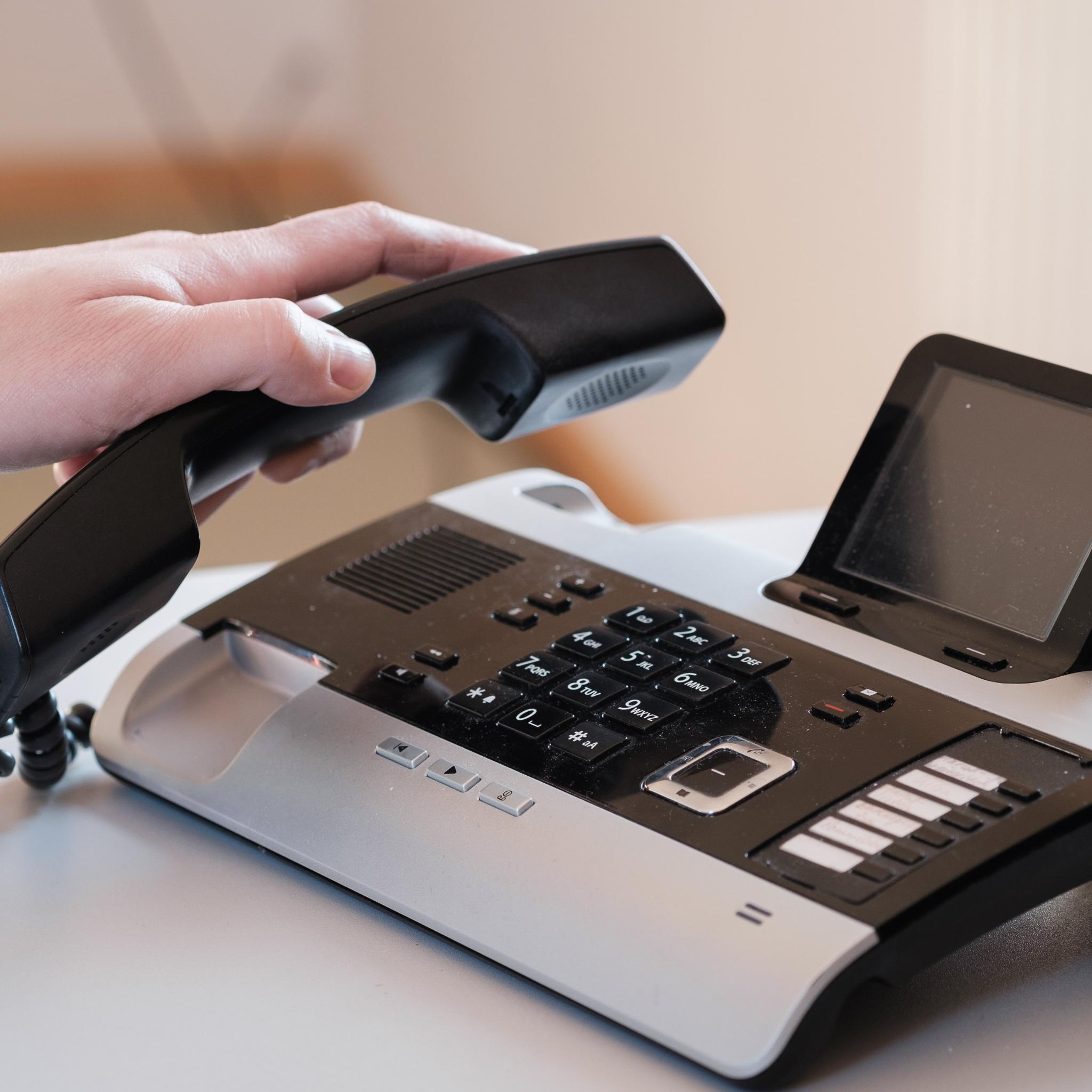 Hand hebt Telefonhörer an (c) Pfarrbriefservice Hand hebt Telefonhörer an